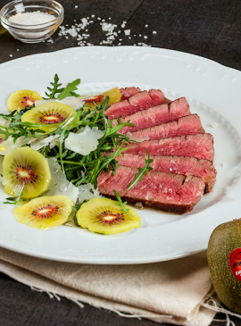 Beef tagliata with rocket, kiwi and parmesan petals