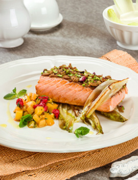 Salmone in crosta di pane integrale e pistacchi su letto di indivia belga piastrata con dadolata di kiwi, ribes e menta