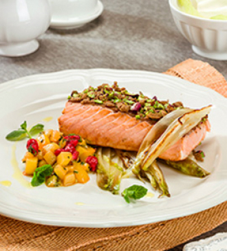 Salmone in crosta di pane integrale e pistacchi su letto di indivia belga piastrata con dadolata di kiwi, ribes e menta